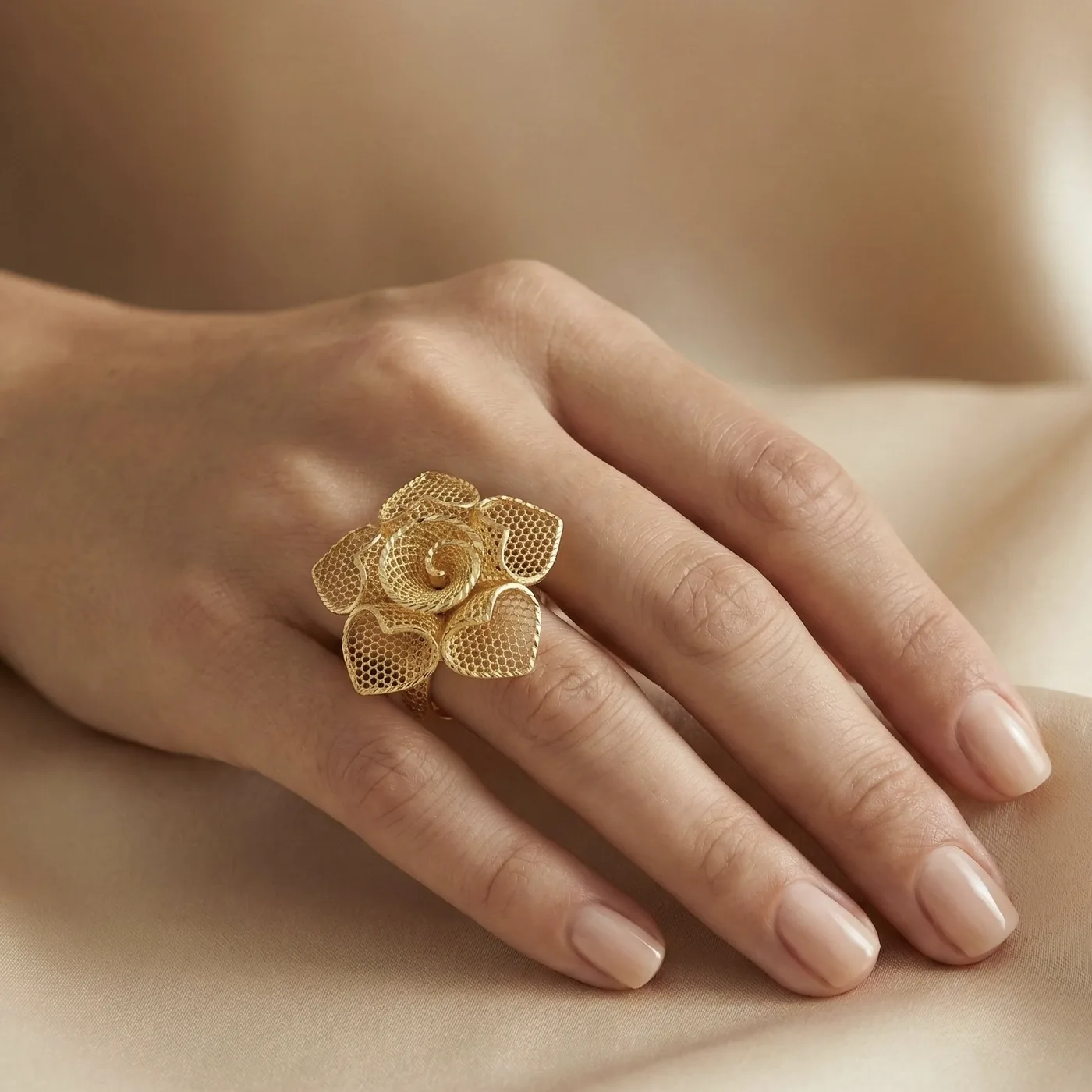 21K gold flower design ring with textured details on a model hand and white background
